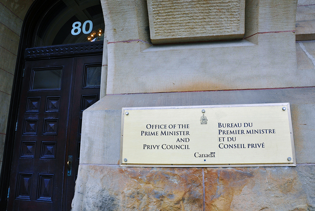 A photo of the sign for the Office of the Prime Minister and Privy Council on a stone wall at 80 Wellington Street in Ottawa, Canada.