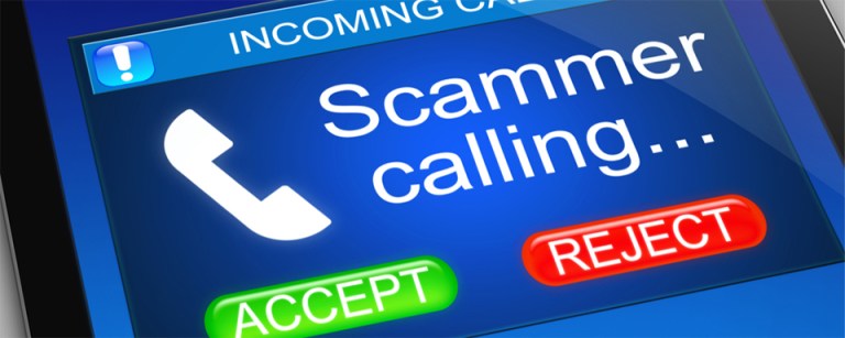 Close up of a smart phone showing an incoming call marked SCAMMER.